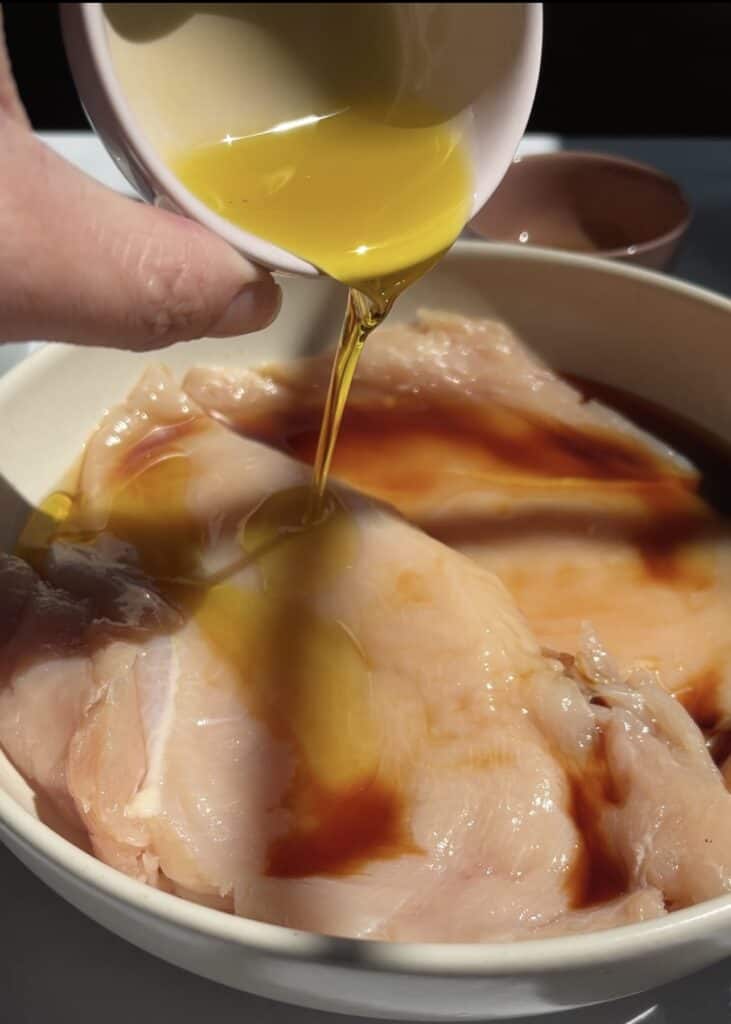 adding olive oil to the marinade