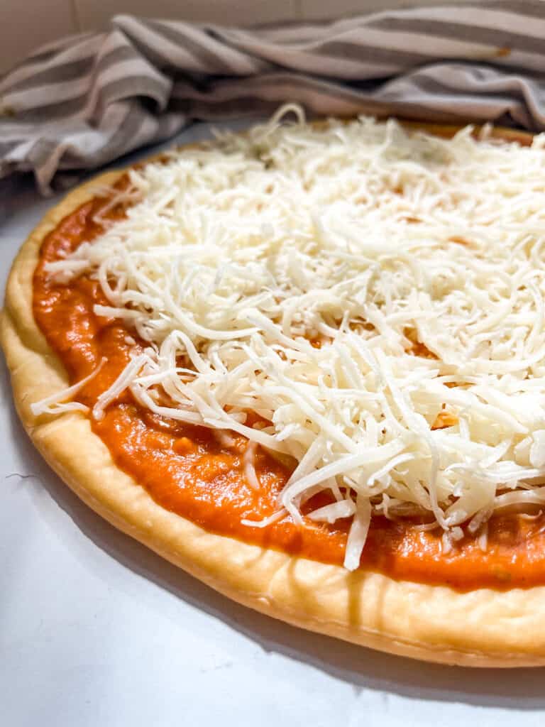 gluten free pizza crust with pumpkin sauce and mozzarella cheese